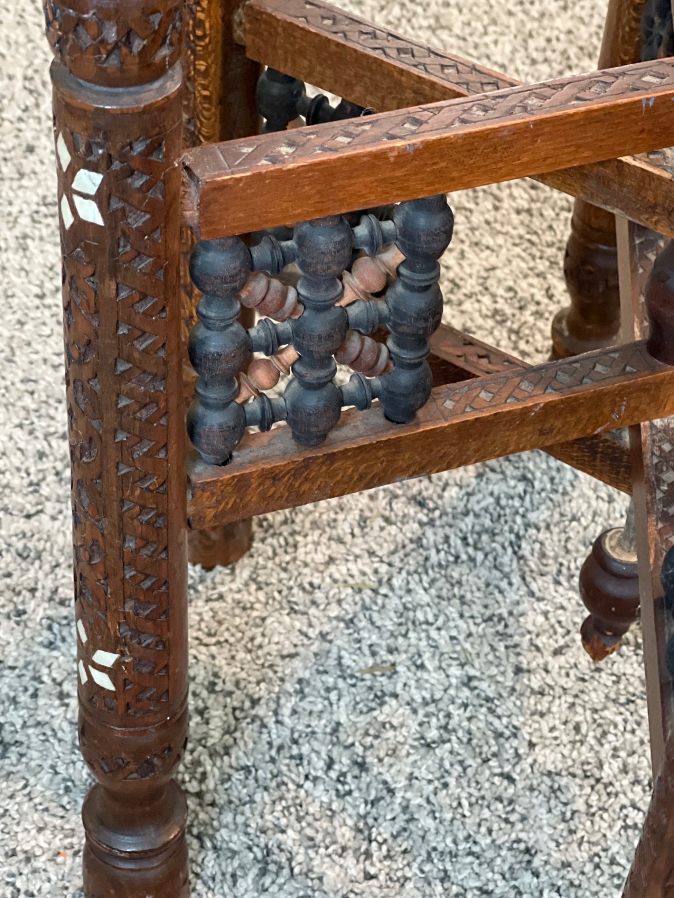 Round brass engraved tray/table with carved wooden chair frame, and red patterned rug - image 6 of 11