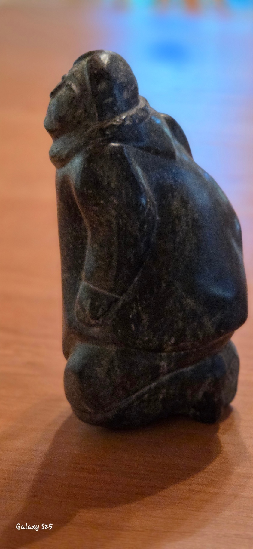 Inuit Soapstone Carving – Kneeling Figure in Traditional Parka Hand-carved stone sculpture depicting a kneeling Inuit figure wearing a traditional hooded parka, with detailed facial features and a naturalistic, weighted posture. - image 3 of 3