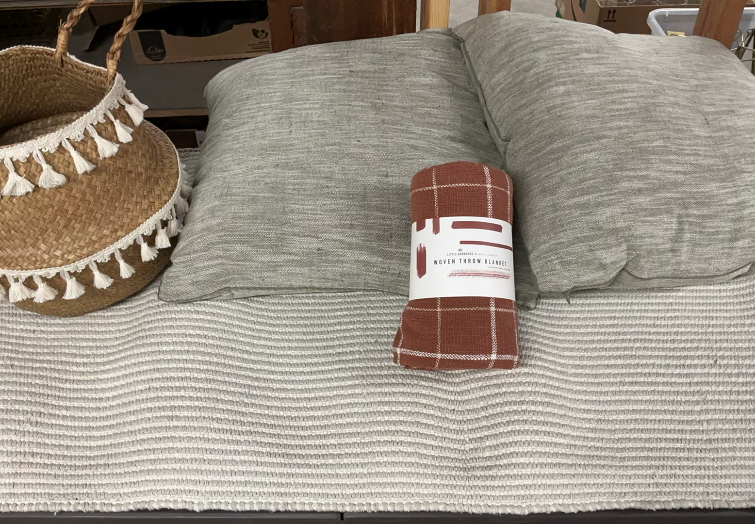 Woven throw blanket, straw basket with tassels, grey cushions, and tassel rug - image 1 of 8