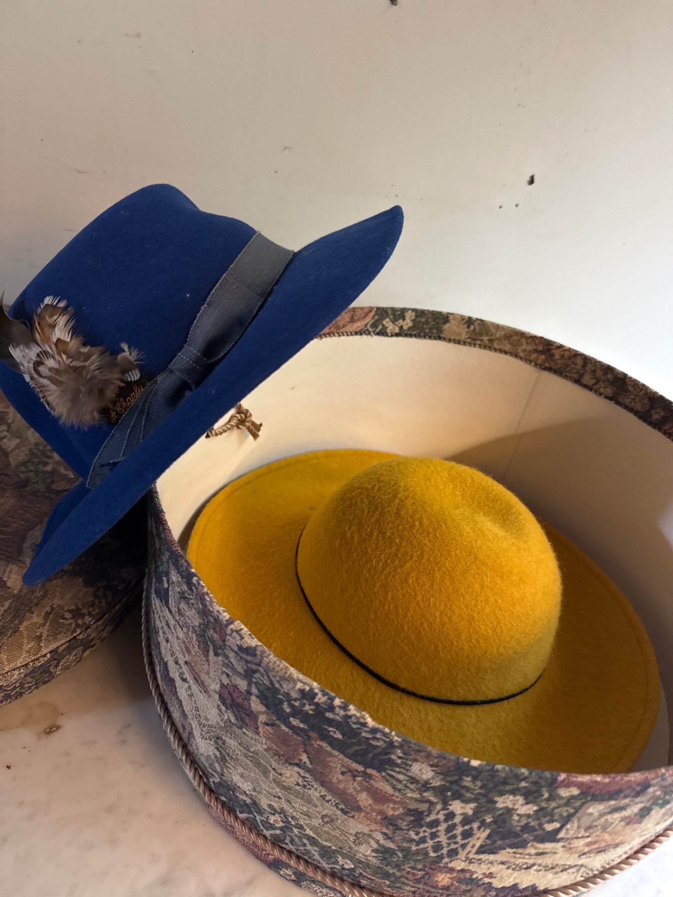Round tapestry hatbox with blue and yellow hats - image 2 of 4