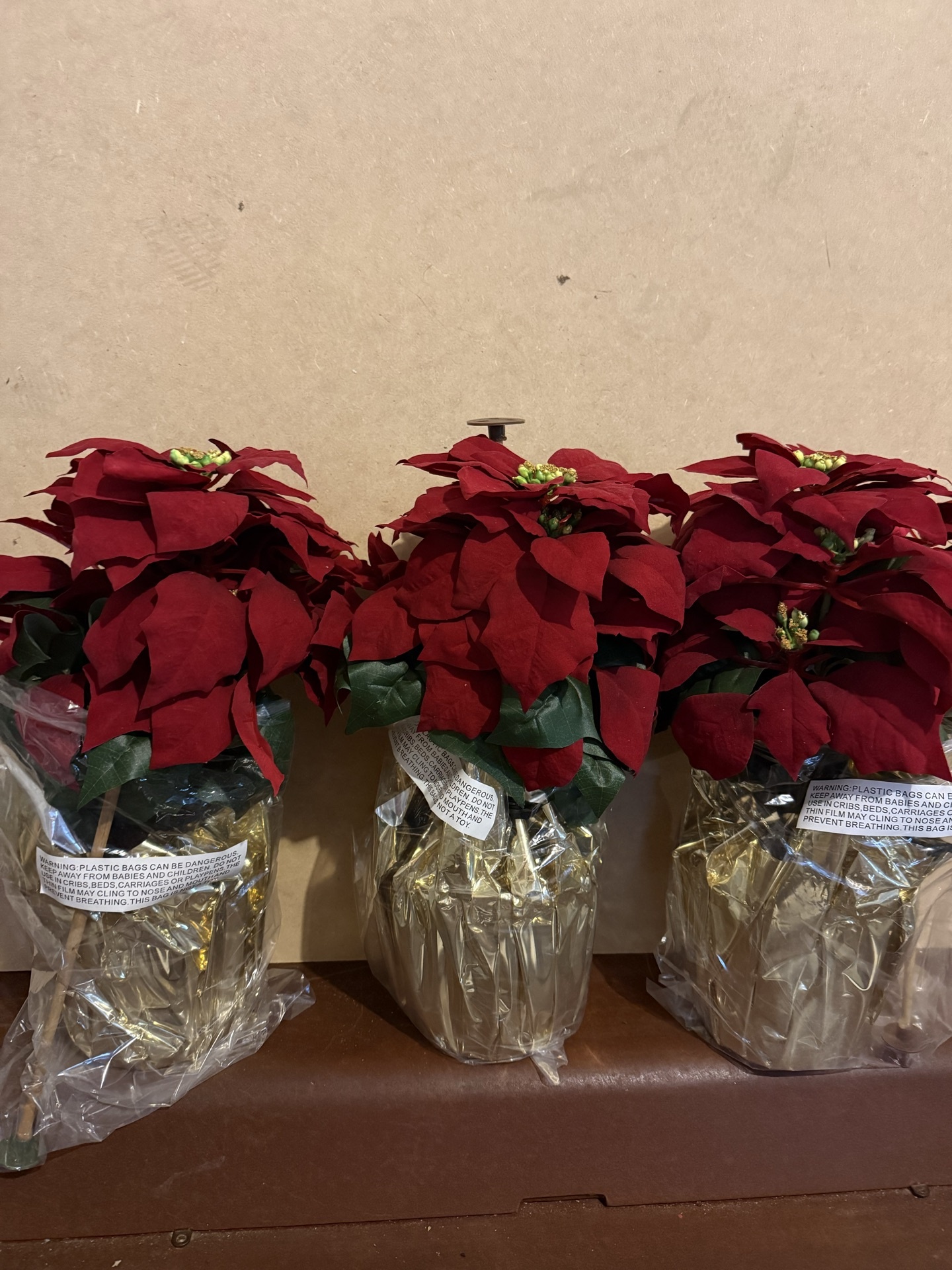 Three red poinsettia plants in plastic-wrapped pots - image 1 of 4