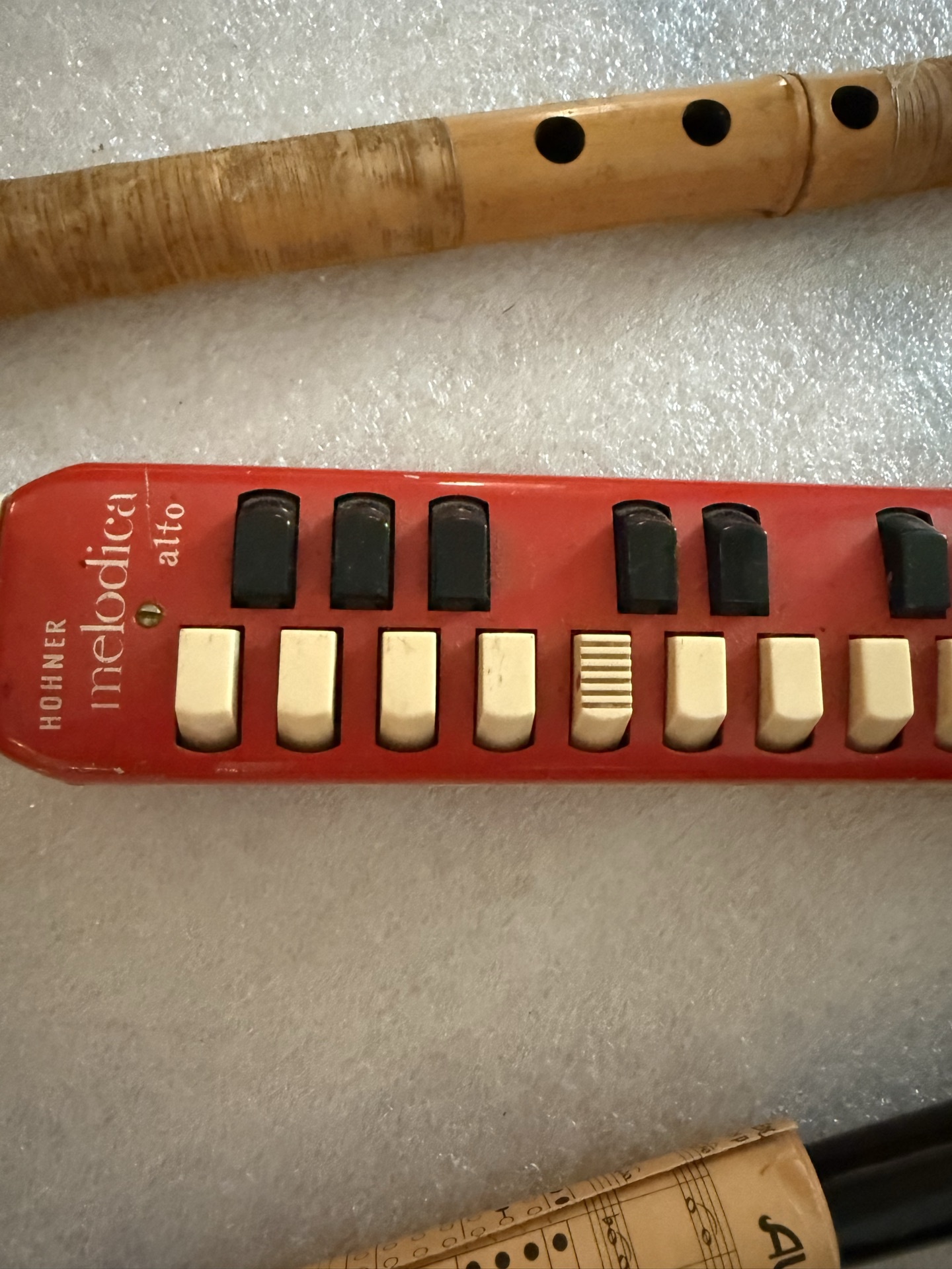 Red Hohner melodica, wooden recorder, and black  wind instrument - image 3 of 5