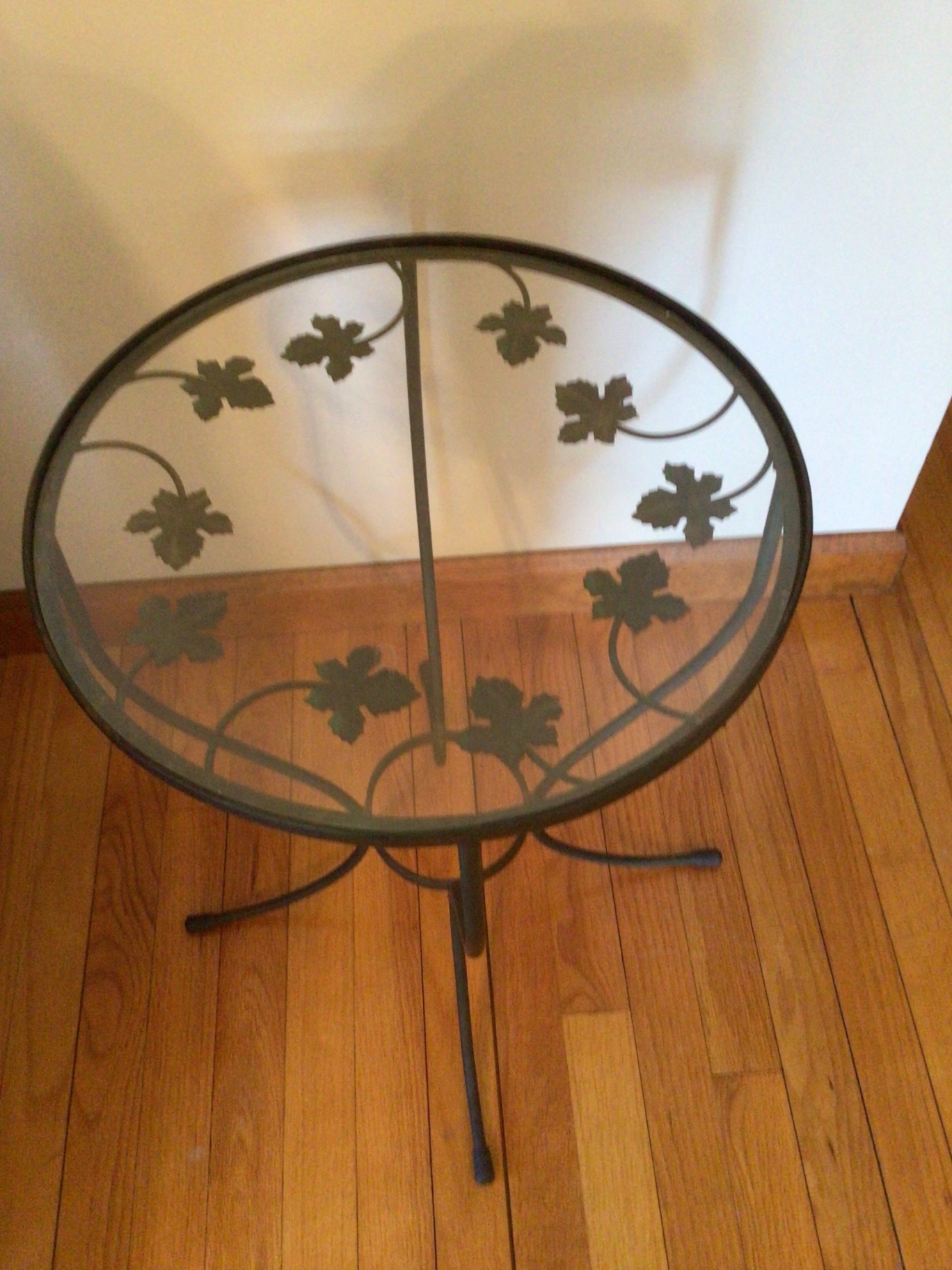 Round glass-top metal end table with ivy leaf motif - image 1 of 2