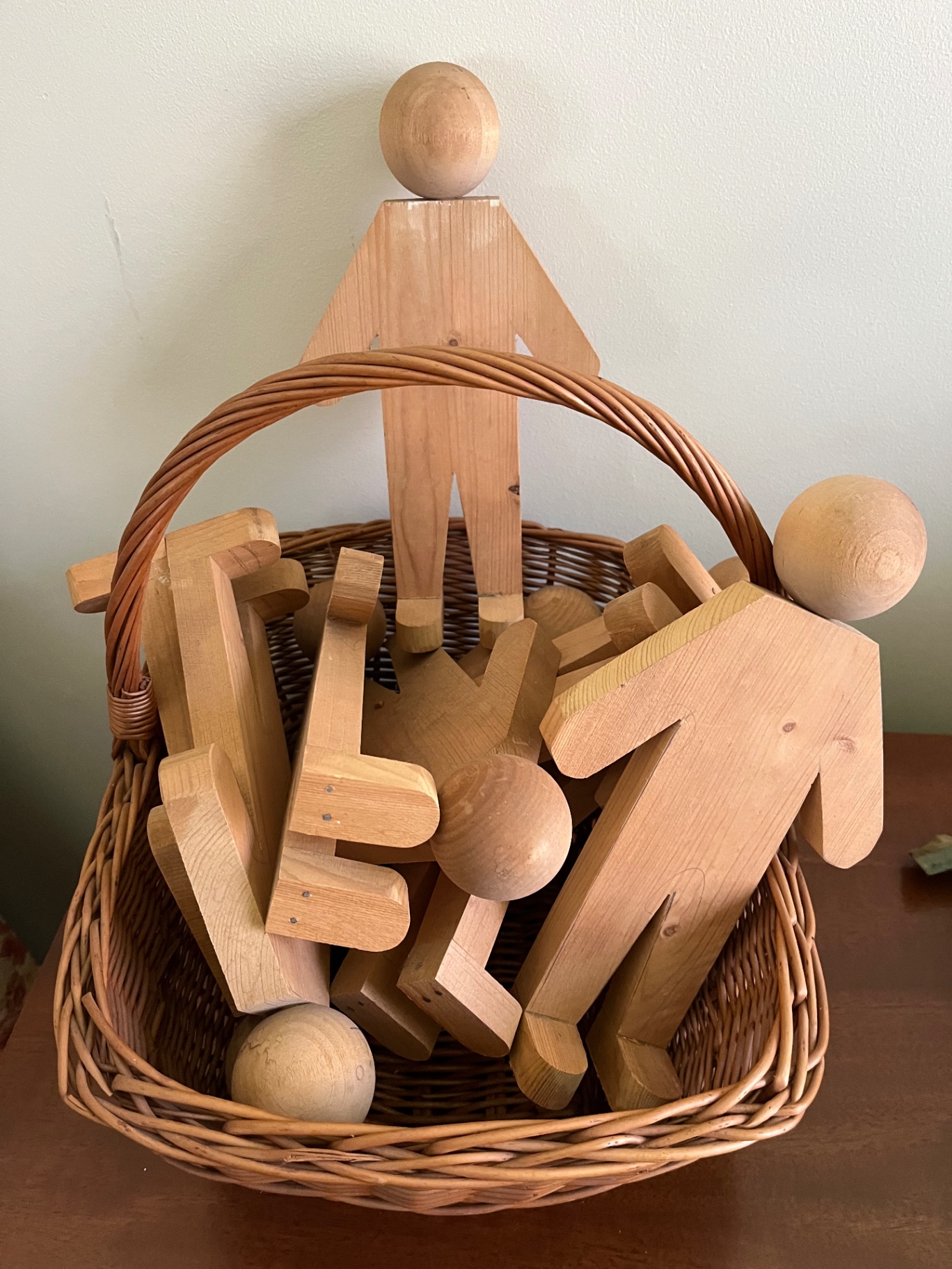Wooden humanoid figures  in wicker basket - image 1 of 1