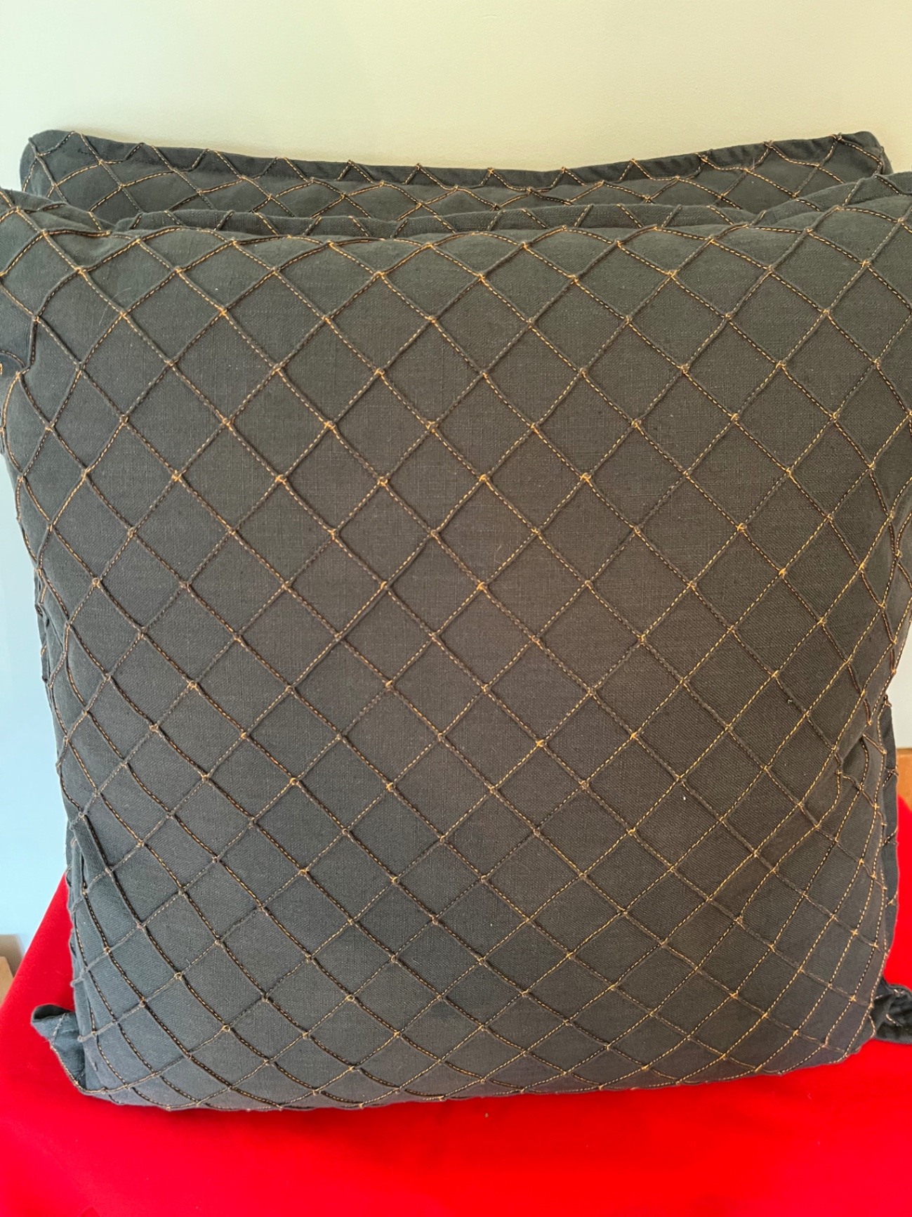 Two grey quilted throw pillows with orange thread accent 25x 25 - image 1 of 2