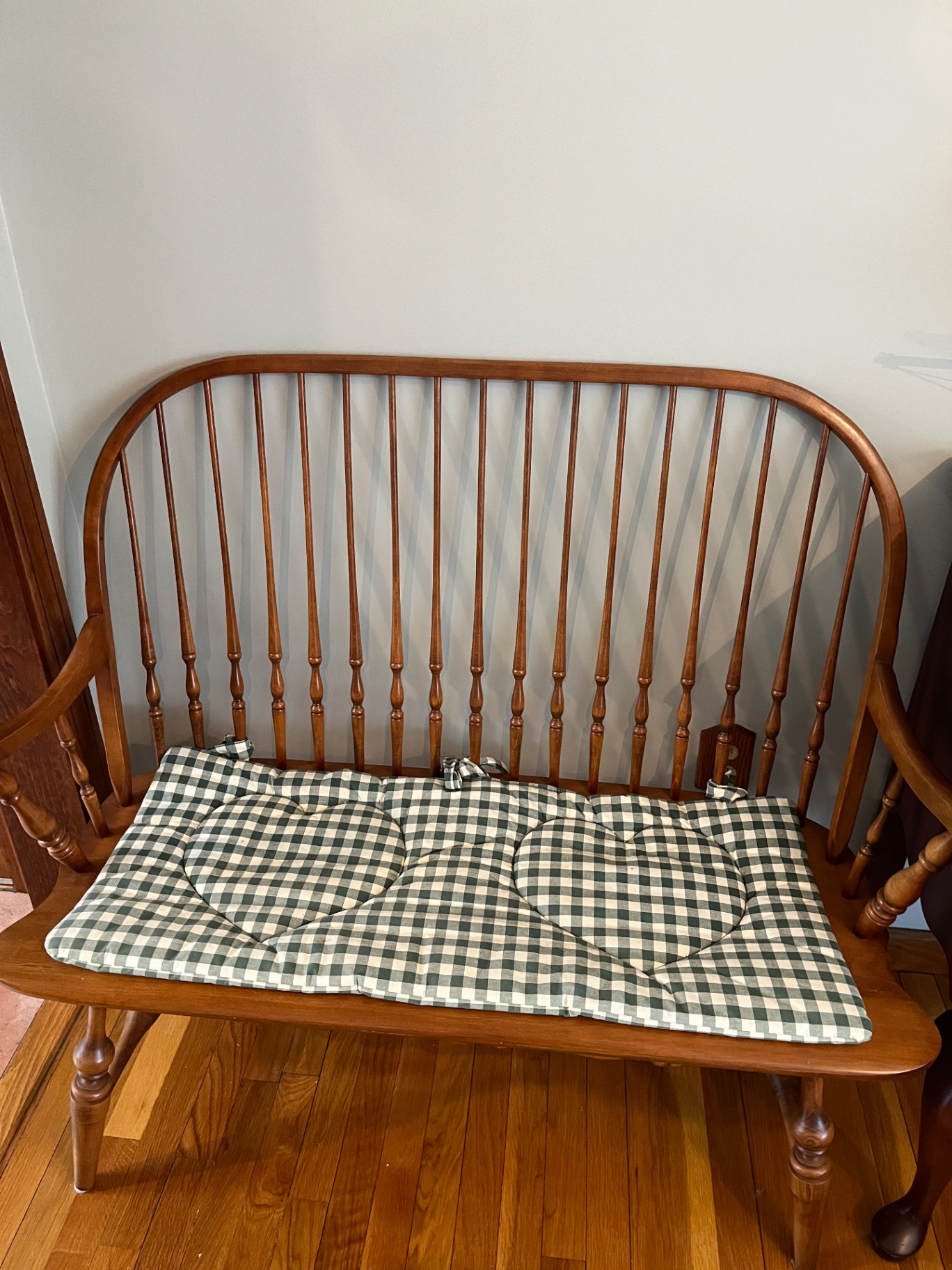 Wooden spindle-back bench with plaid cushion - image 1 of 1