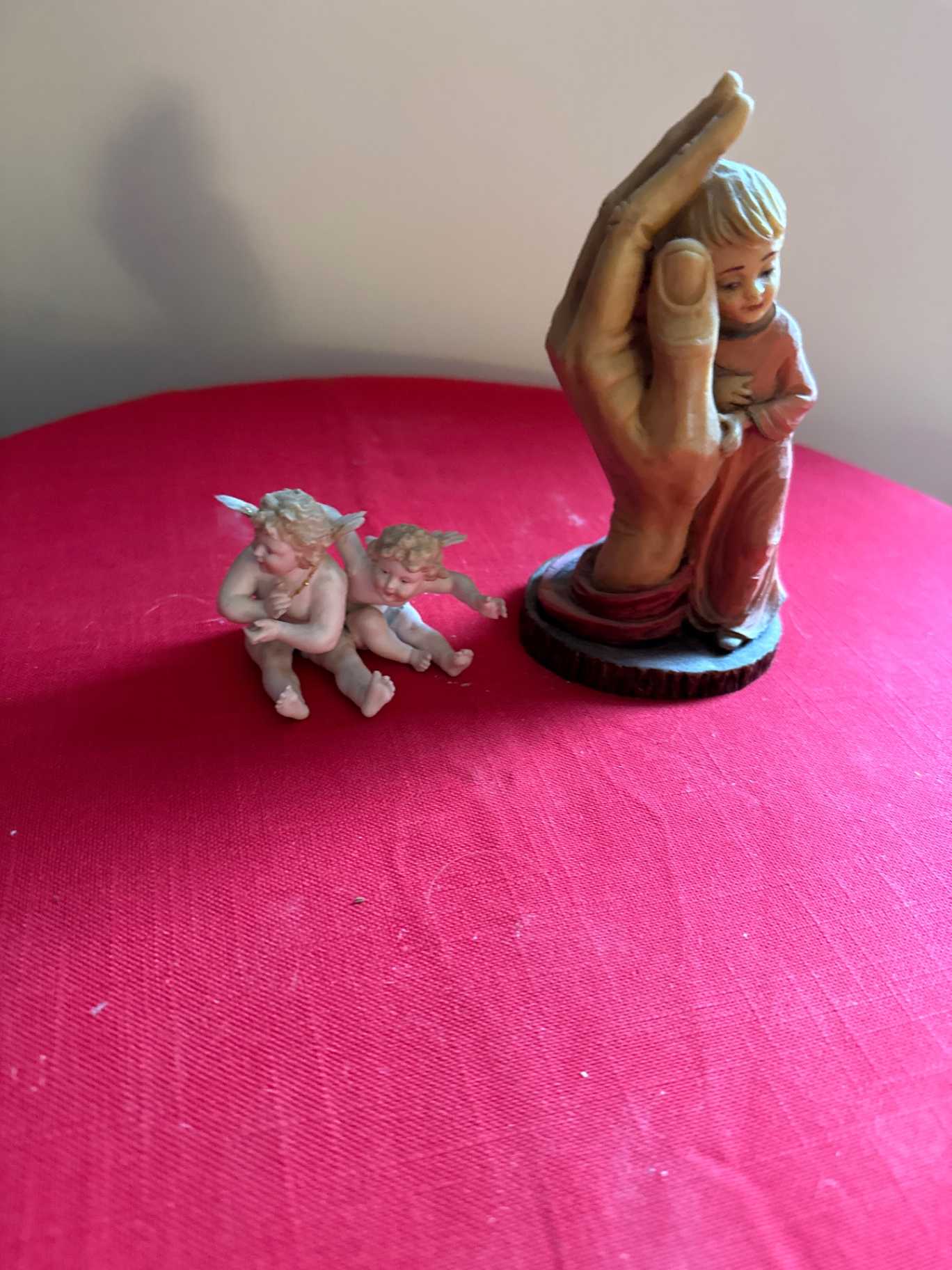 Religious figurine group: hand sculpture cradling a baby and a Tiffany cherub - image 1 of 4