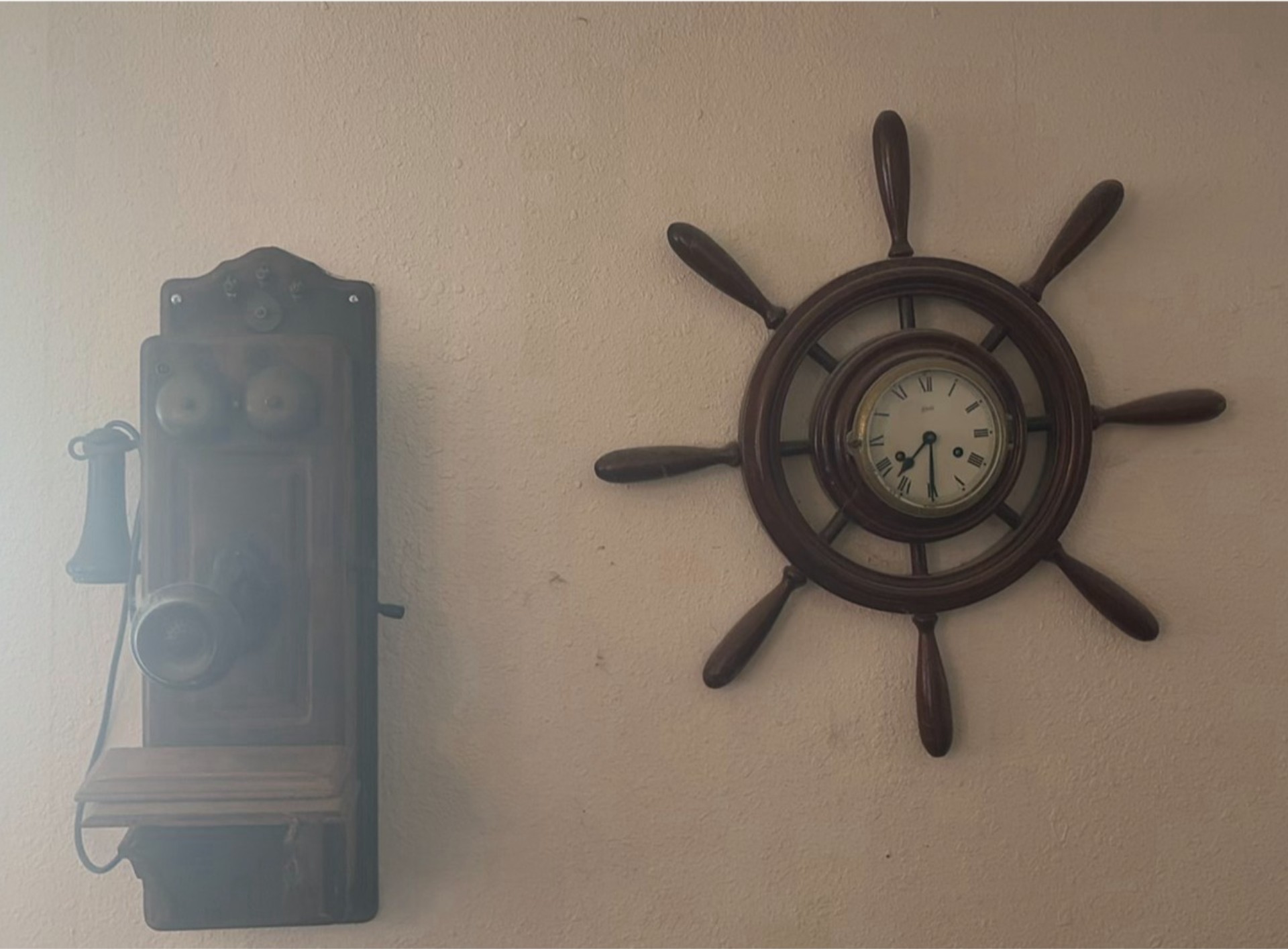 Vintage wall-mounted ship wheel clock, antique telephone, and wooden wall rack - image 1 of 8