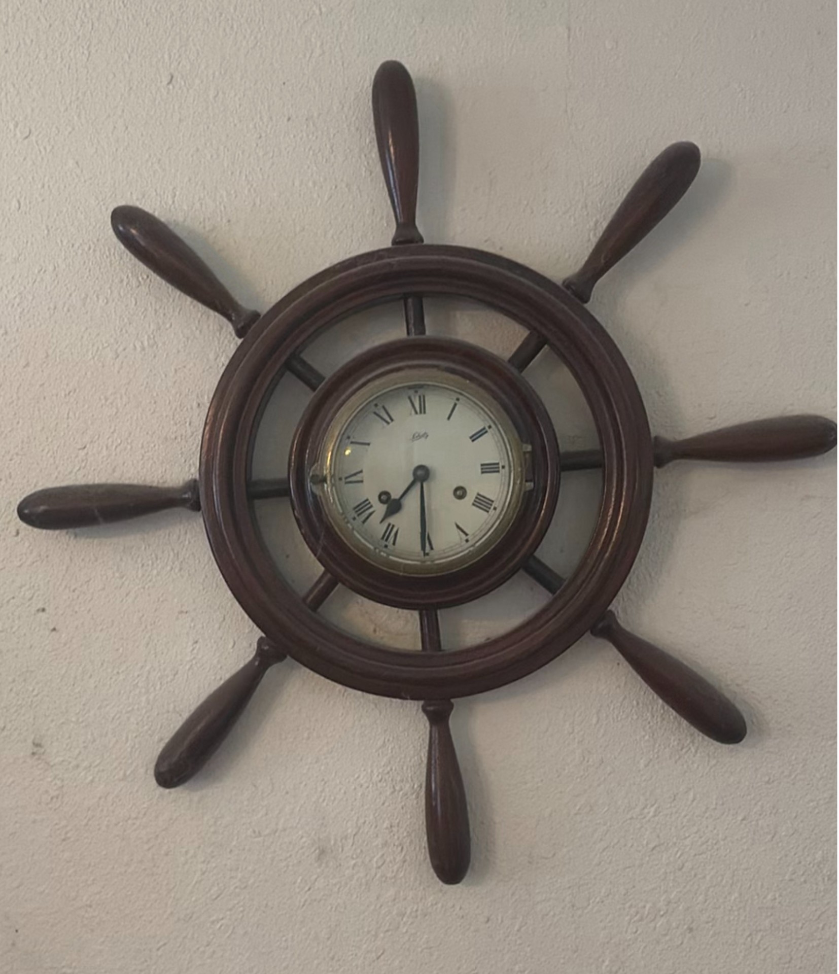 Vintage wall-mounted ship wheel clock, antique telephone, and wooden wall rack - image 5 of 8