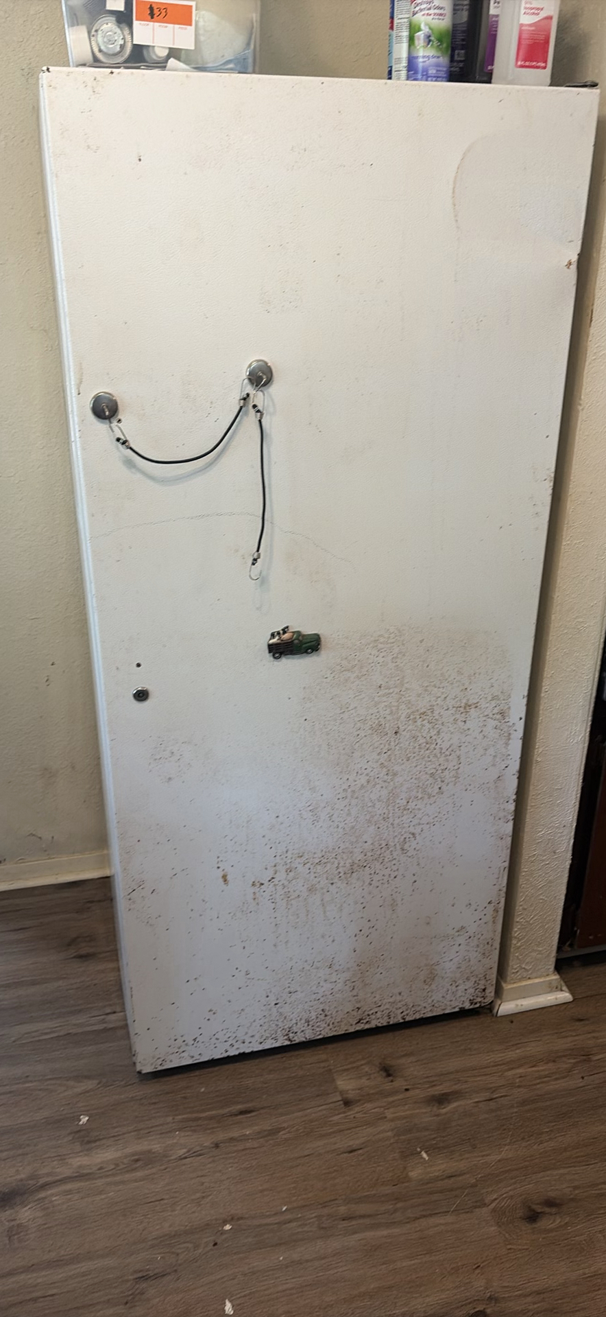 White upright refrigerator with assorted stored items - image 1 of 4