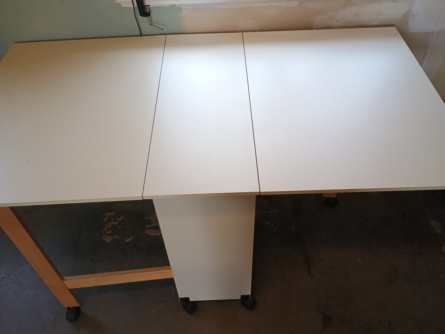 White foldable table with central pedestal and wooden legs on casters - image 2 of 6