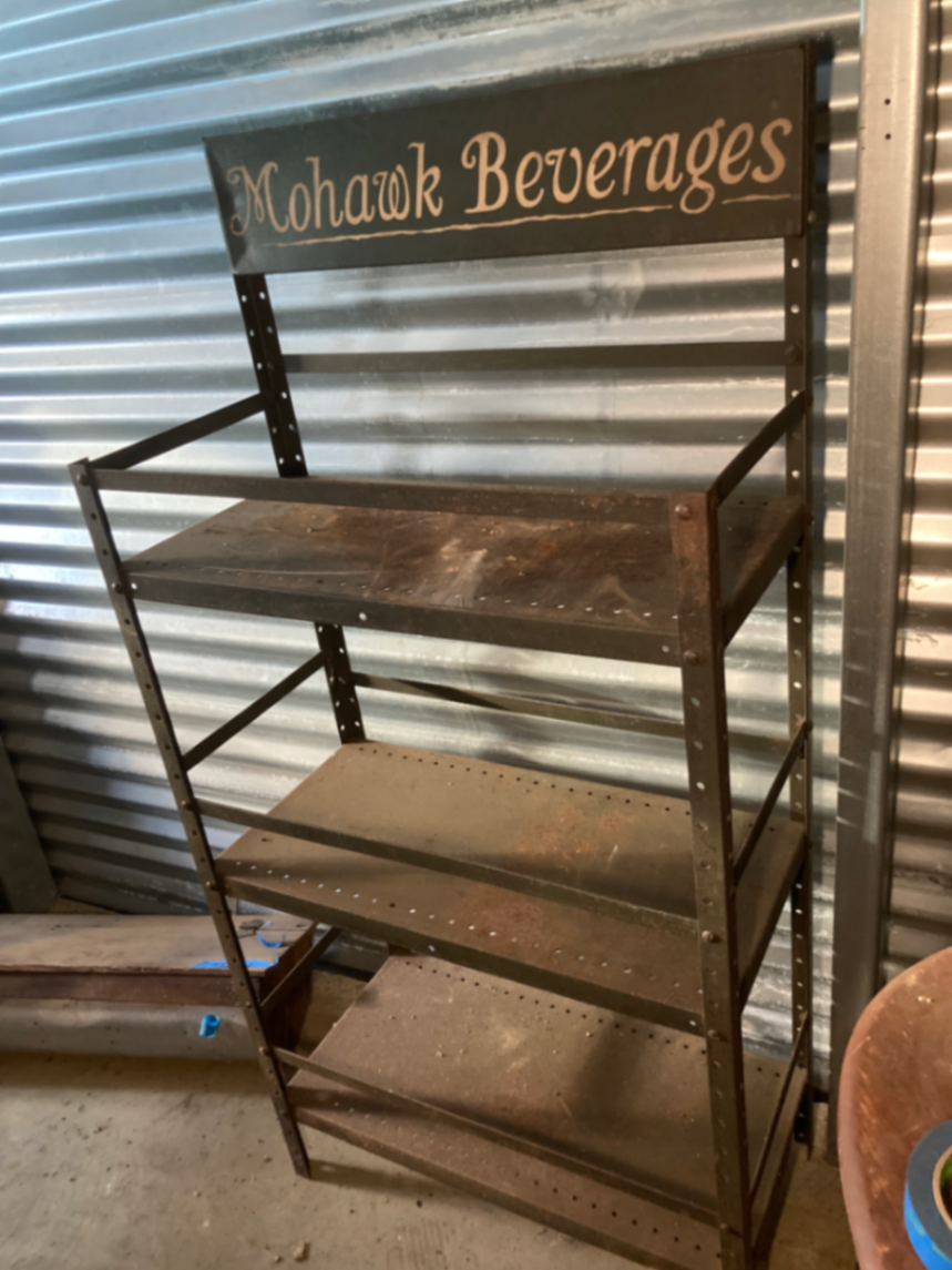 Industrial metal shelving unit with Mohawk Beverages sign - image 1 of 5