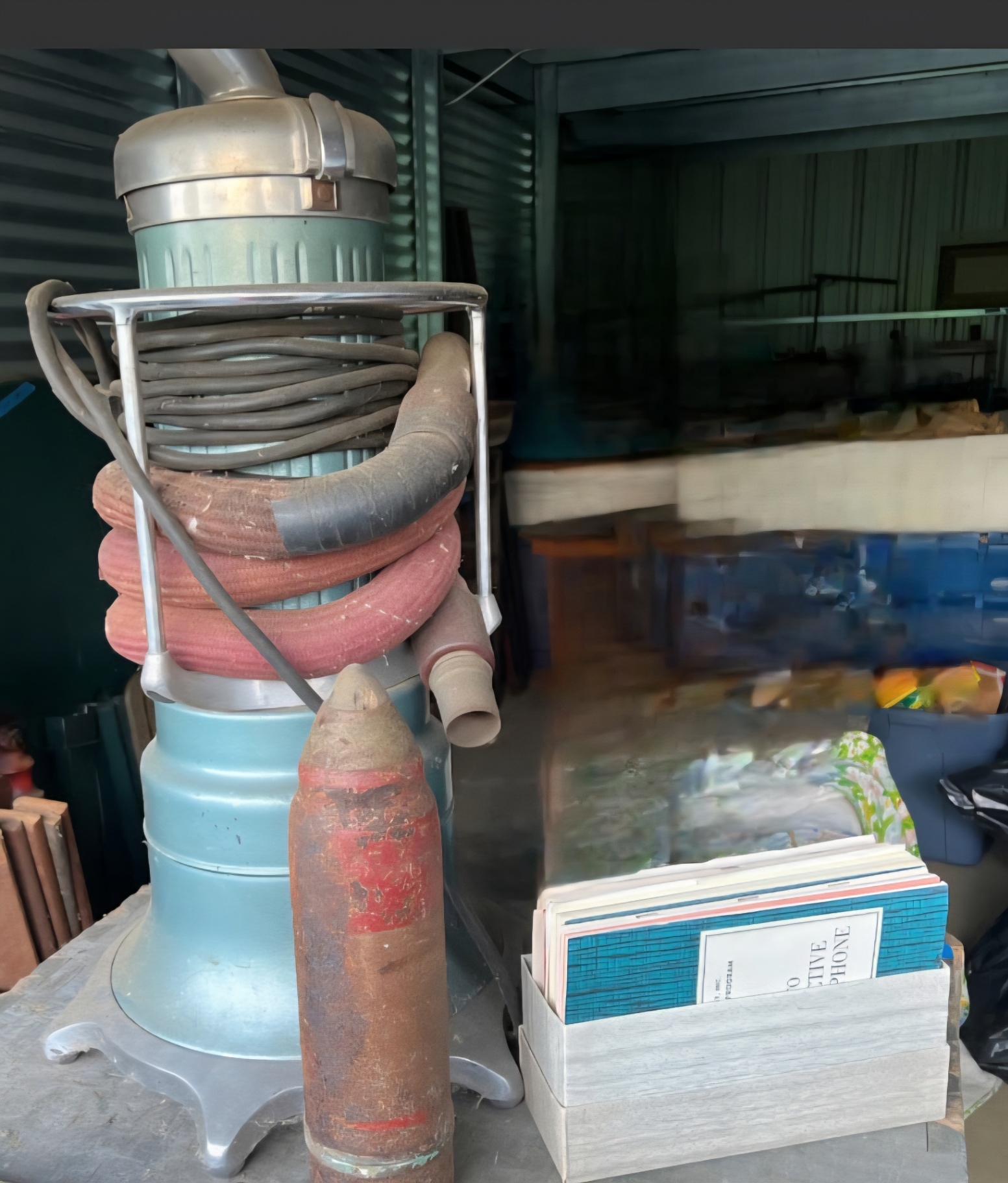 Vintage vacuum cleaner, rusted cylinder, and vintage books - image 1 of 6