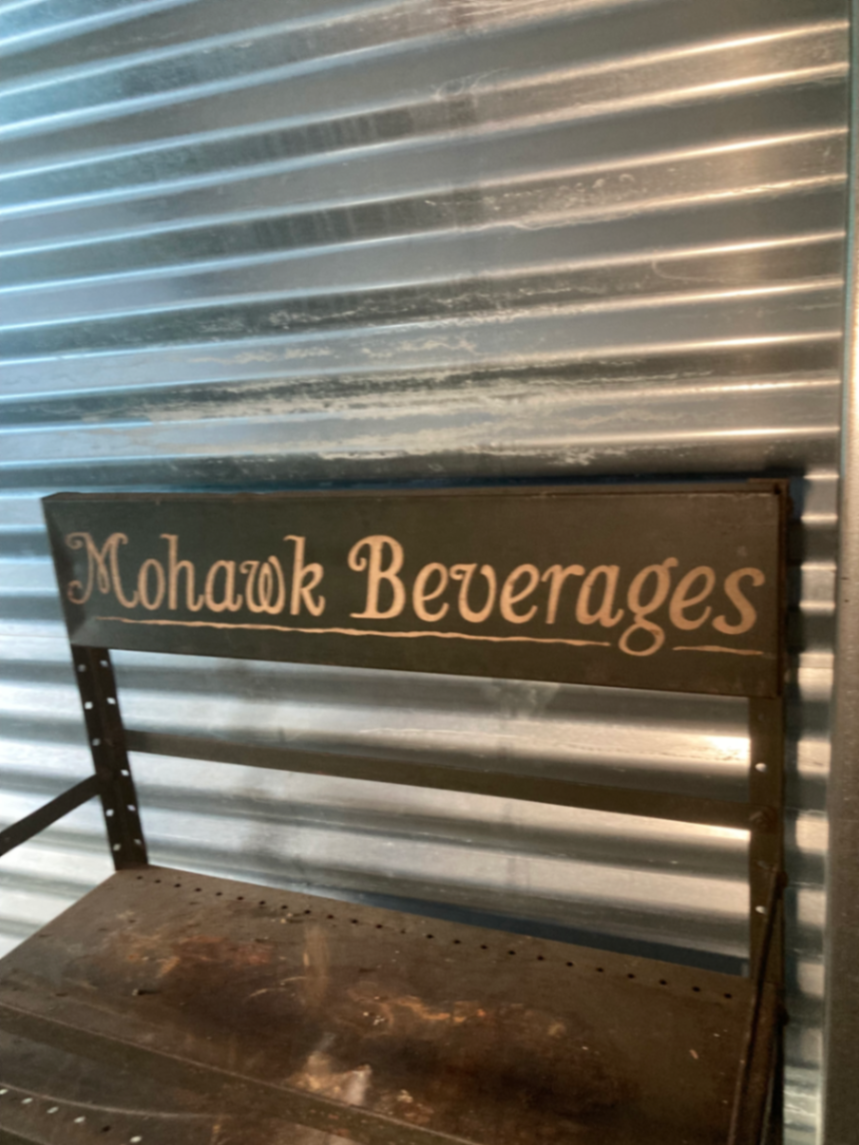 Industrial metal shelving unit with Mohawk Beverages sign - image 3 of 5