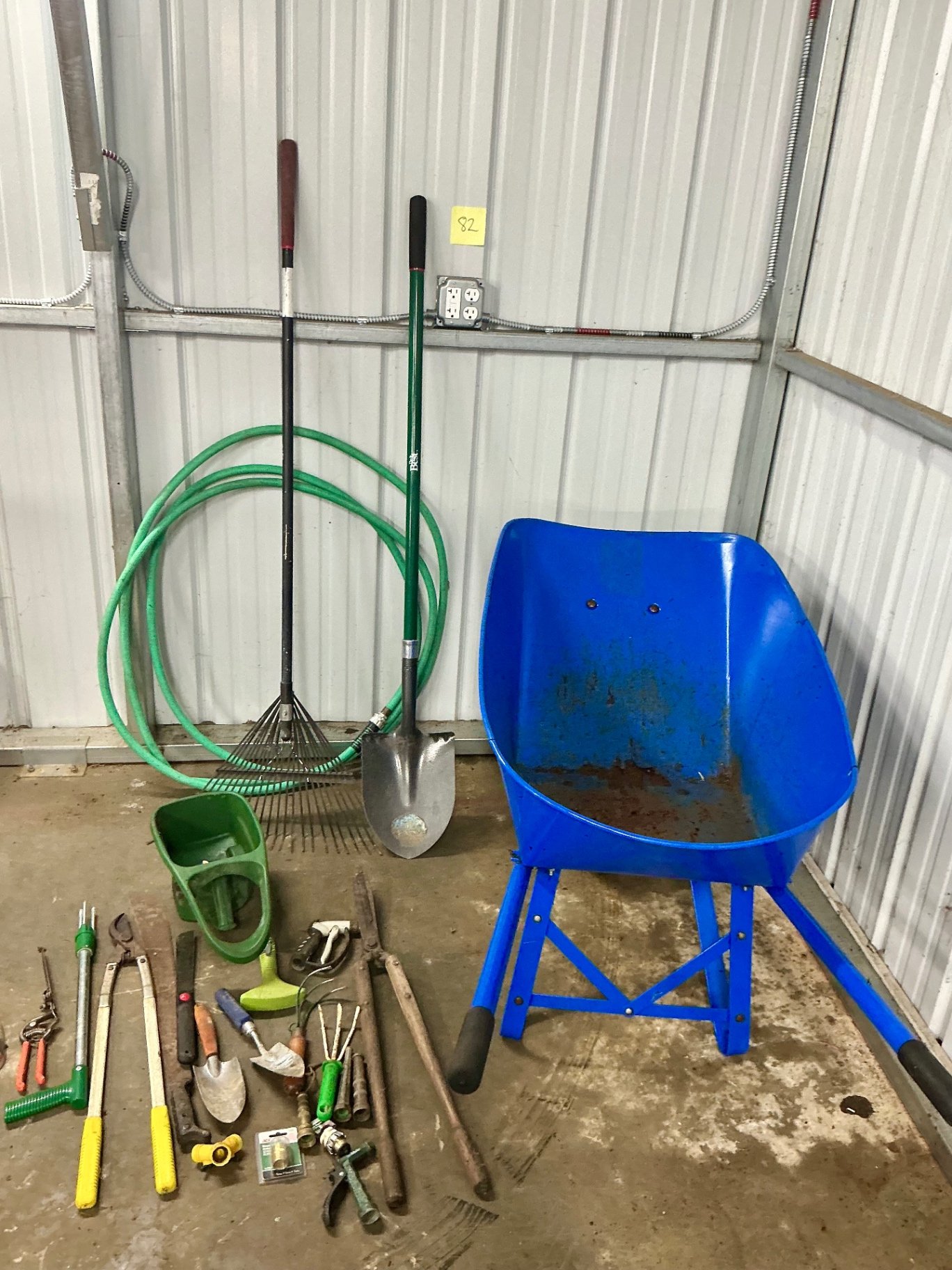 Blue wheelbarrow with garden tools and hose - image 1 of 6
