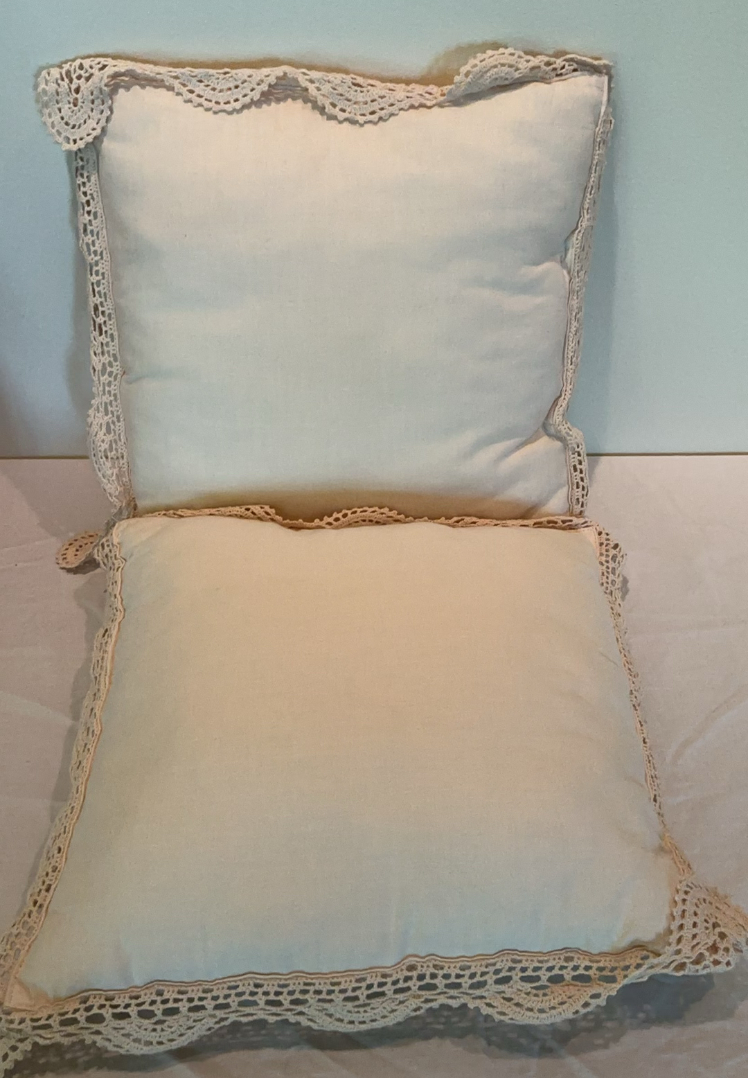 Decorative pillows with crocheted lace covers and red throw blanket - image 3 of 5