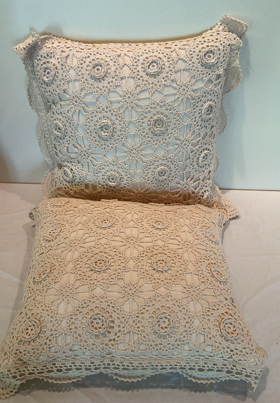 Decorative pillows with crocheted lace covers and red throw blanket - image 2 of 5