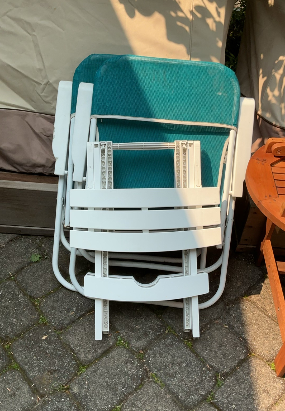Outdoor patio furniture set: turquoise mesh chairs with white frames, a white folding table, and stacked white folding chairs - image 6 of 6