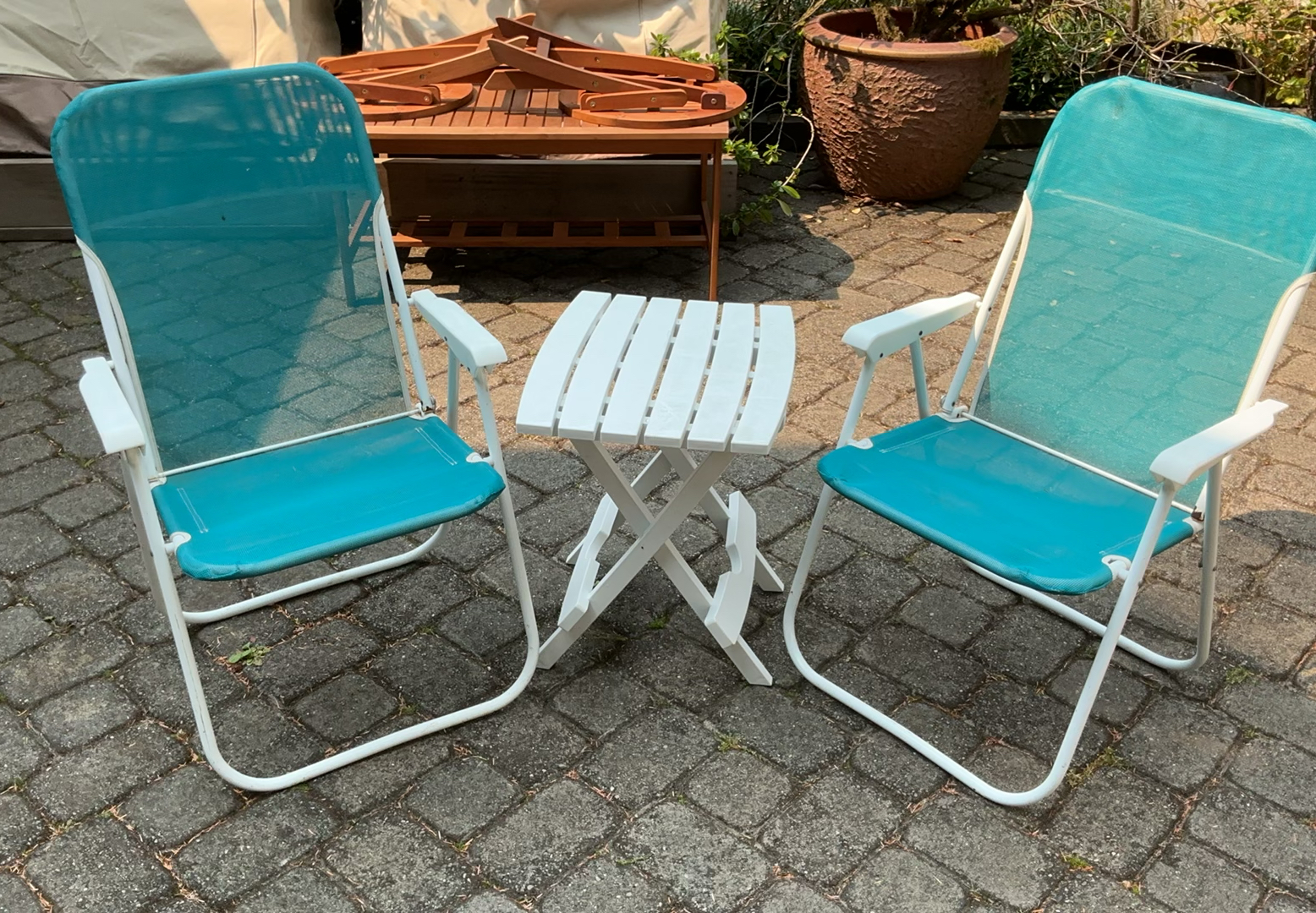 Outdoor patio furniture set: turquoise mesh chairs with white frames, a white folding table, and stacked white folding chairs - image 1 of 6