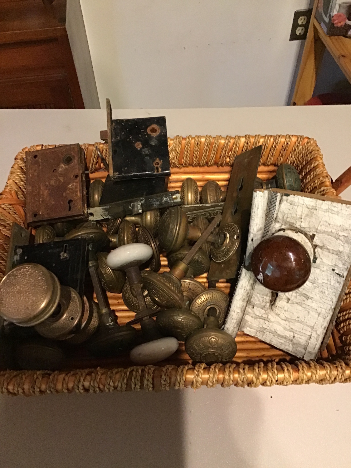 Assorted vintage door knobs and hardware in a basket - image 1 of 1