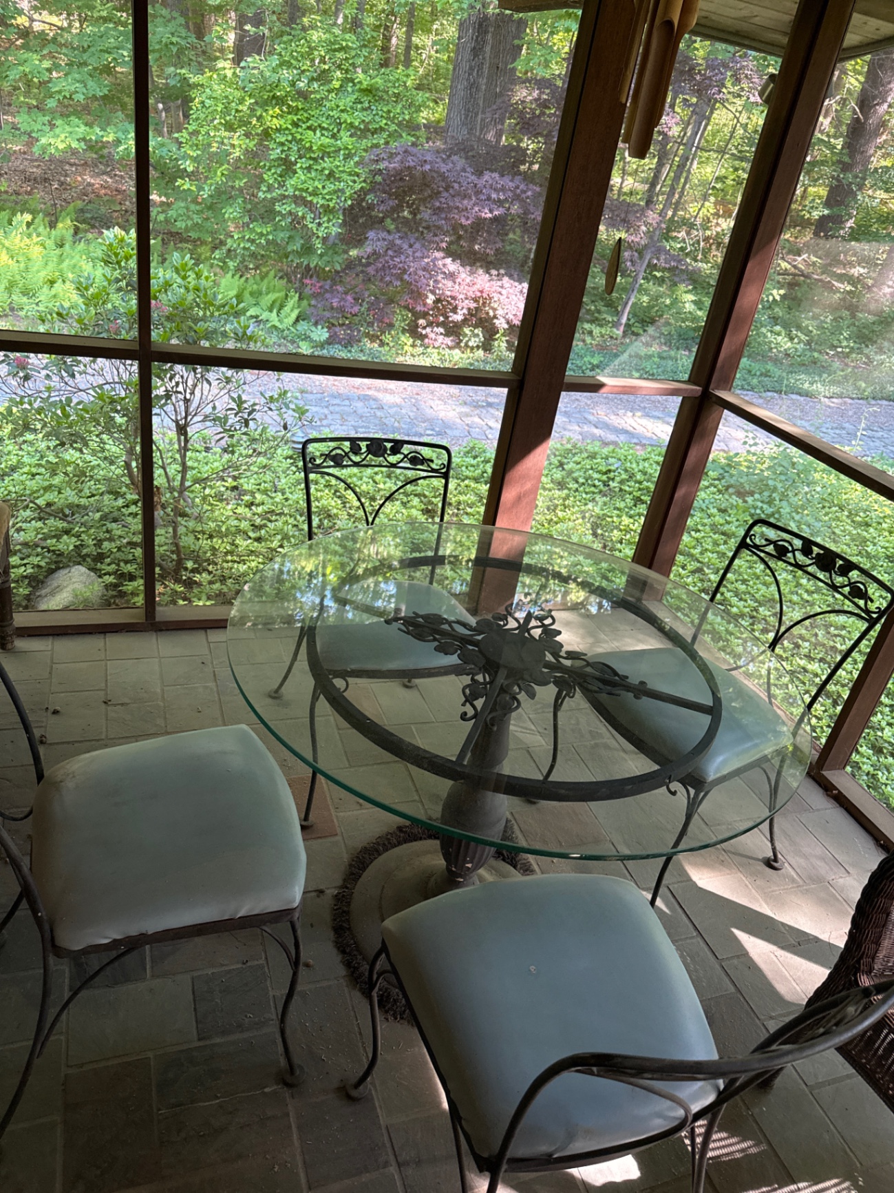 Round glass dining table with four cushioned metal chairs - image 1 of 4
