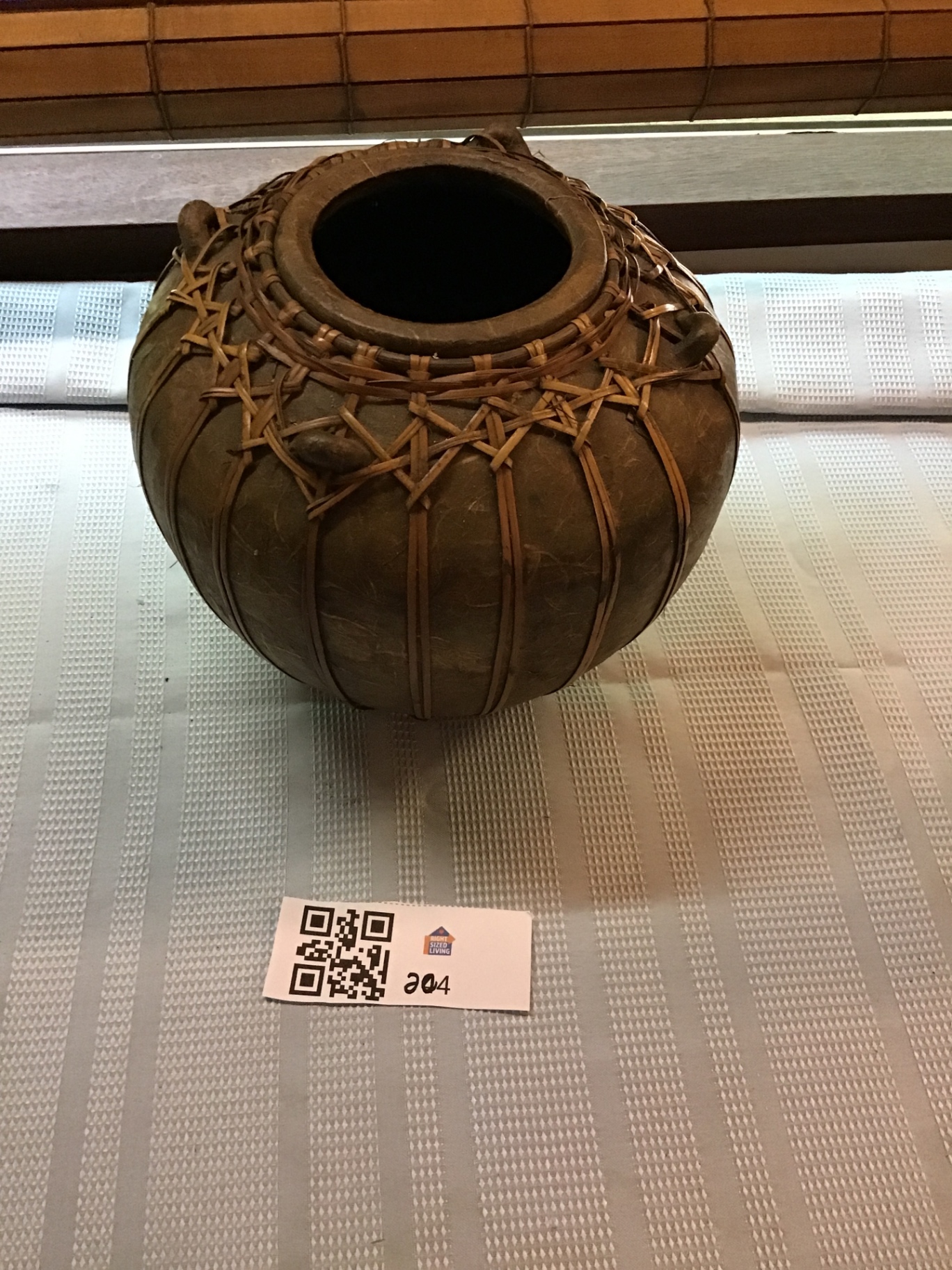 Round ceramic pot wrapped in woven rattan - image 1 of 4