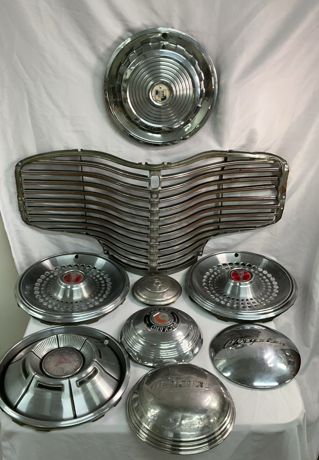 Vintage chrome car hubcaps and grille pieces - image 1 of 8