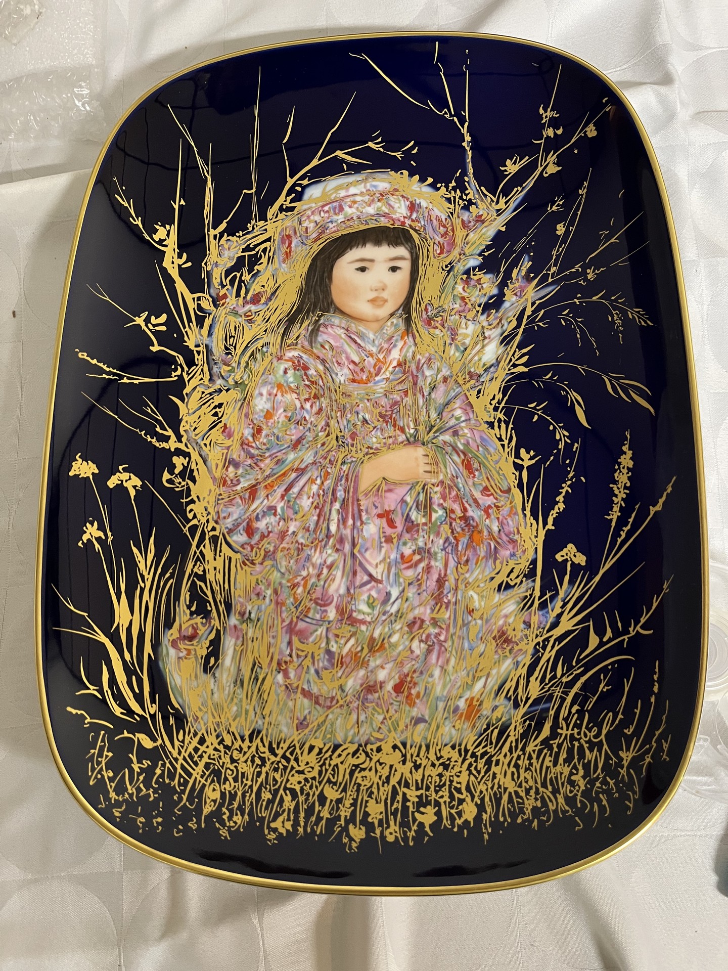 Decorative ceramic plate with robed figure and gold botanical motif - image 1 of 3
