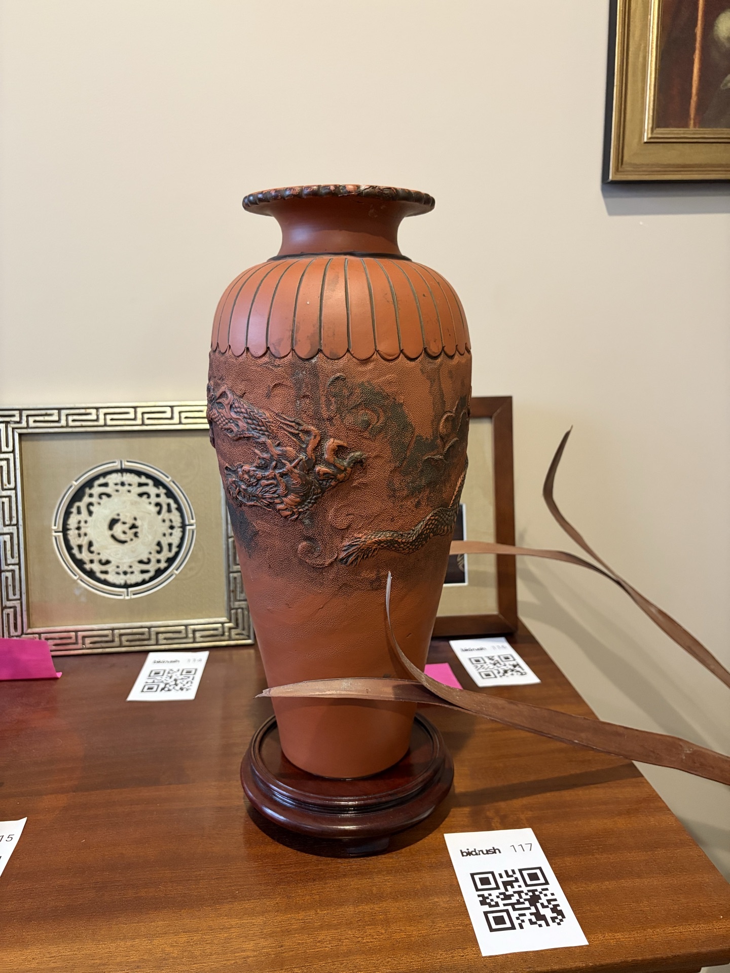 Terracotta vase with dragon relief on wooden stand - image 1 of 9