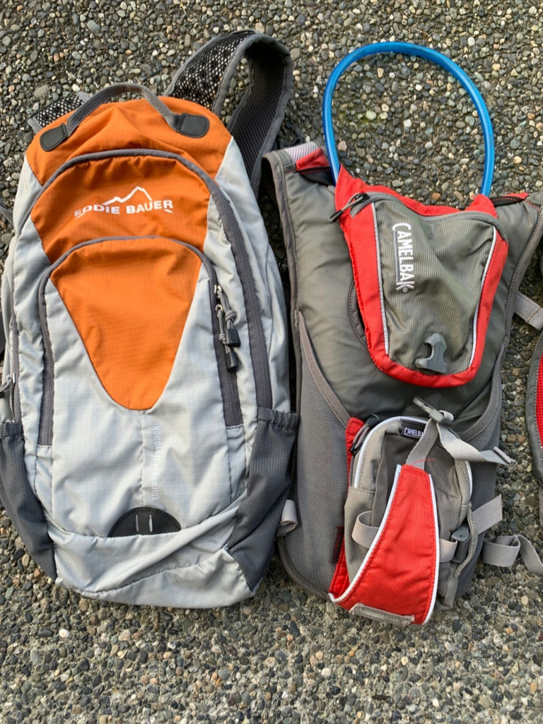 Cycling gear set with helmets, hydration packs, and high-visibility vests - image 3 of 7