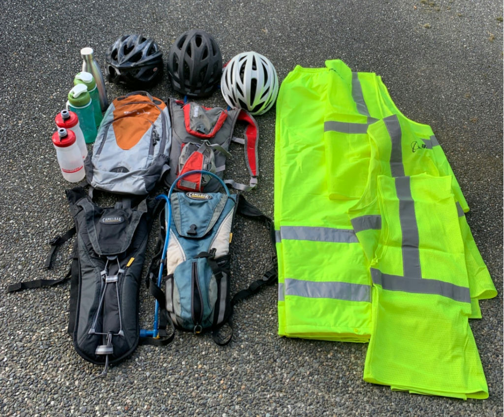 Cycling gear set with helmets, hydration packs, and high-visibility vests - image 1 of 7
