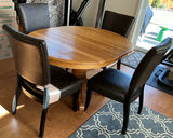 Round wooden dining table with pedestal base and four upholstered chairs - thumbnail 1 of 5