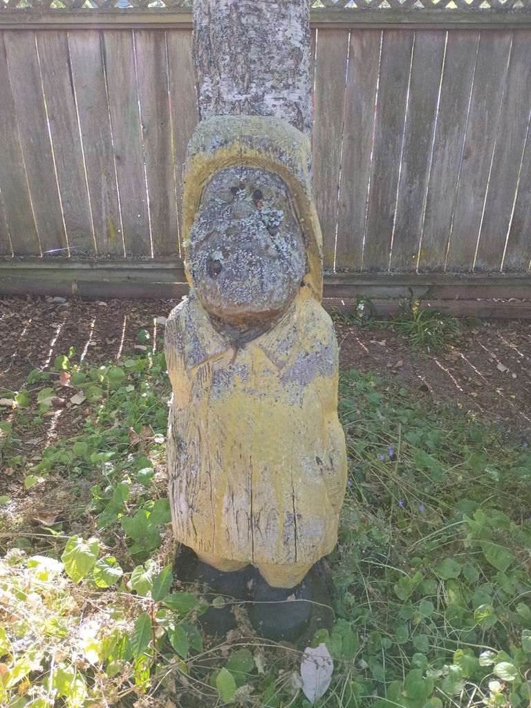 Weathered yellow wooden statue yard art - image 1 of 3