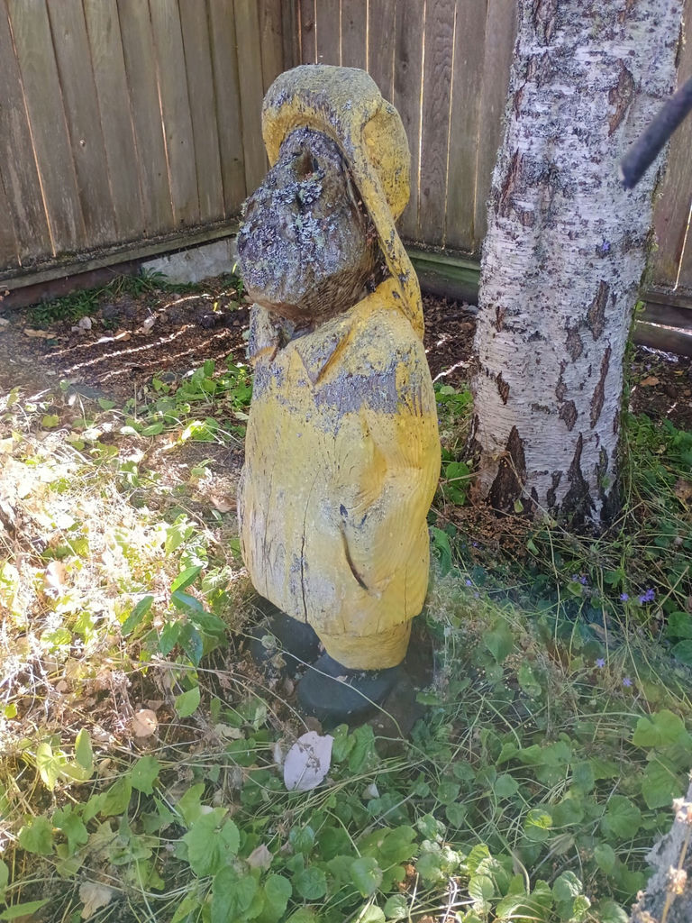 Weathered yellow wooden statue yard art - image 2 of 3