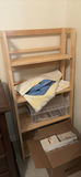 Wooden open-shelf storage with linens and decor items - thumbnail 1 of 5