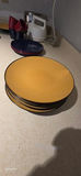 Stack of yellow-inside, black-outside bowls with kitchenware and tea box - thumbnail 5 of 8