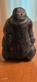 Inuit Soapstone Carving – Kneeling Figure in Traditional Parka Hand-carved stone sculpture depicting a kneeling Inuit figure wearing a traditional hooded parka, with detailed facial features and a naturalistic, weighted posture. - thumbnail 1 of 3