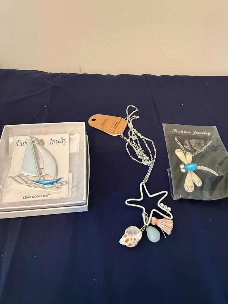 Assorted fashion jewelry: sailboat pendant, dragonfly brooch, and shell charms - image 1 of 4