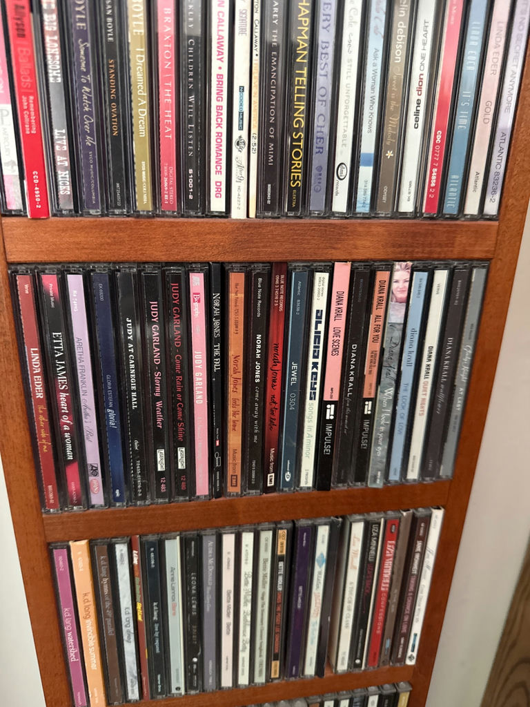 Tall wooden CD storage tower with stacked CD cases - image 4 of 5