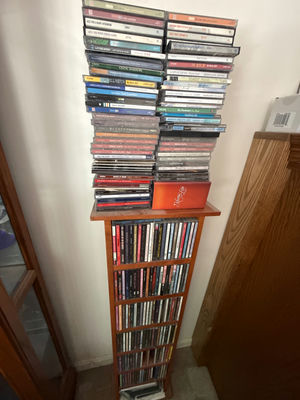 Tall wooden CD storage tower with stacked CD cases - Image 1 of 5