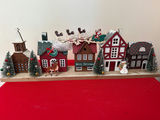 New in box - Christmas village with houses, trees, and holiday figures - thumbnail 1 of 2