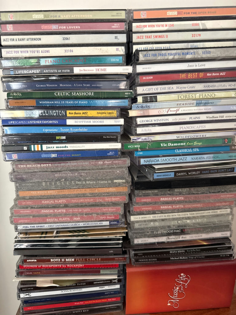 Tall wooden CD storage tower with stacked CD cases - image 3 of 5