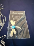 Assorted fashion jewelry: sailboat pendant, dragonfly brooch, and shell charms - thumbnail 4 of 4