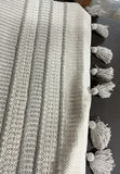 Woven throw blanket, straw basket with tassels, grey cushions, and tassel rug - thumbnail 7 of 8