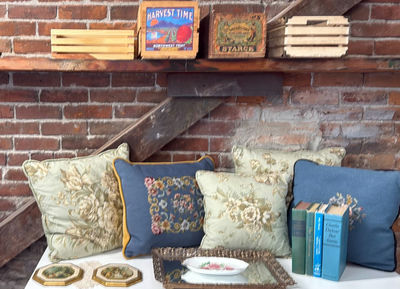 Vintage home décor collection: pillows, picture frames, crates, plate, mirror, and books - Image 1 of 9