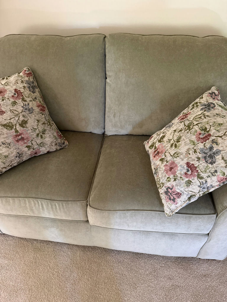 Olive-green fabric sofa with floral pillows - image 2 of 3