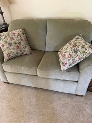Olive-green fabric sofa with floral pillows - Image 1 of 3