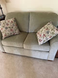 Olive-green fabric sofa with floral pillows - thumbnail 1 of 3