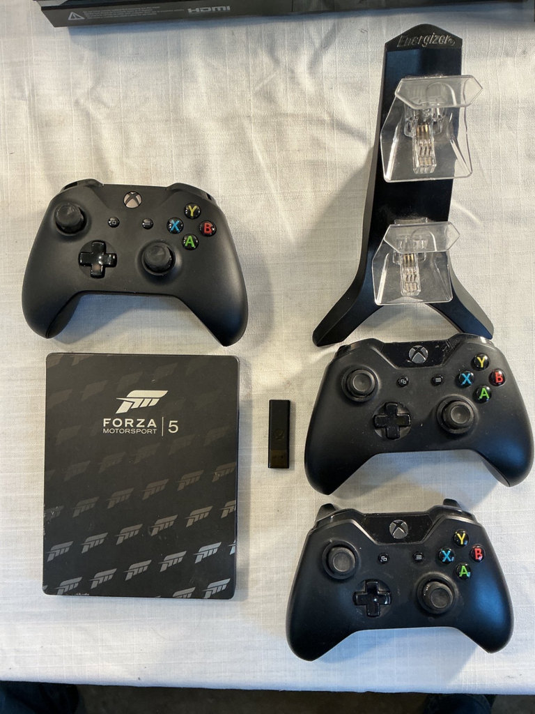 Xbox One X console with three controllers and a game - image 2 of 8