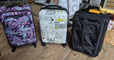 Three rolling suitcases: purple floral, cityscape white, and black - thumbnail 1 of 5